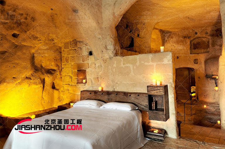 現(xiàn)代人造山洞旅行酒店被棕櫚樹和松樹環(huán)繞營造出熱帶f 格背景